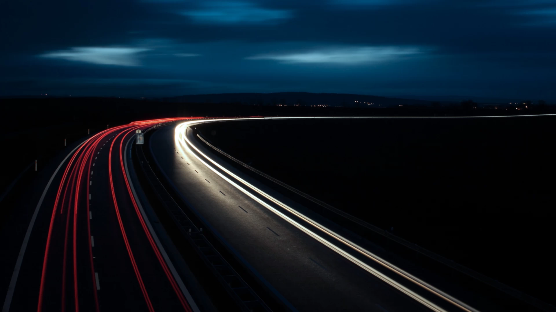 Nachtaufnahme Autobahn mit roten und weißen Lichtspuren – Symbol für Mobilität, Geschwindigkeit und moderne Verkehrsinfrastruktur